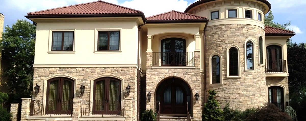 Stucco and stone house with terracotta tile roof and turret